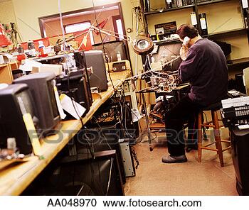 Stock Photography - man talking on 
the phone and 
repairing electronics. 
fotosearch - search 
stock photos, 
pictures, images, 
and photo clipart