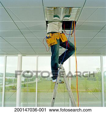 Stock Photography - man on step ladder, 
working through 
gap in ceiling, 
low section. fotosearch 
- search stock 
photos, pictures, 
images, and photo 
clipart