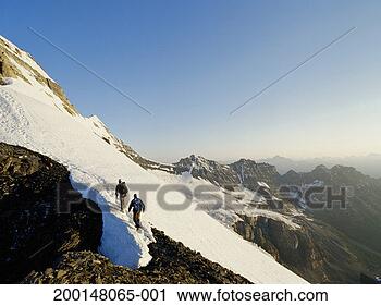Stock Photography - two mountaineers 
ascending snow-covered 
mountain, rear 
view. fotosearch 
- search stock 
photos, pictures, 
images, and photo 
clipart