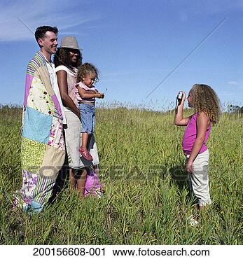 Stock Photography - girl (6-8) taking 
photograph of 
sister (2-4) and 
parents, side 
view. fotosearch 
- search stock 
photos, pictures, 
images, and photo 
clipart