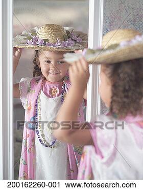 Stock Photography - girl (2-4) wearing 
straw hat, looking 
in mirror, smiling. 
fotosearch - search 
stock photos, 
pictures, images, 
and photo clipart