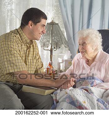 Stock Photography - man with bible 
on lap holding 
hands with senior 
woman, smiling. 
fotosearch - search 
stock photos, 
pictures, images, 
and photo clipart
