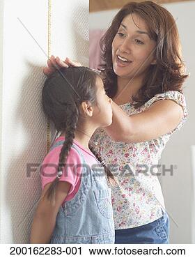 Stock Photography - mother measuring 
daughter's (3-5) 
height against 
wall. fotosearch 
- search stock 
photos, pictures, 
images, and photo 
clipart