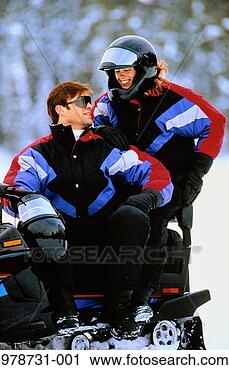 Stock Photography - couple in matching 
clothes on parked 
snowmobile, smiling. 
fotosearch - search 
stock photos, 
pictures, images, 
and photo clipart