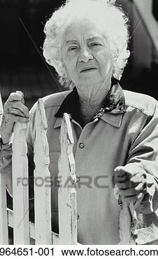 Stock Photography - elderly woman 
standing behind 
white fence (b&w). 
fotosearch - search 
stock photos, 
pictures, images, 
and photo clipart