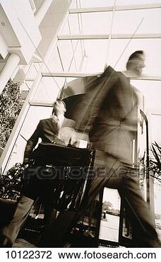 Stock Photo - executives emerging 
from revolving 
door. fotosearch 
- search stock 
photos, pictures, 
images, and photo 
clipart