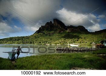 Stock Photo - man by boat in 
bay in bora bora, 
polynesia. fotosearch 
- search stock 
photos, pictures, 
images, and photo 
clipart