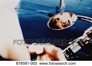 Stock Photo - woman looking 
in wing mirror 
of motorcycle, 
applying lipstick. 
fotosearch - search 
stock photos, 
pictures, images, 
and photo clipart