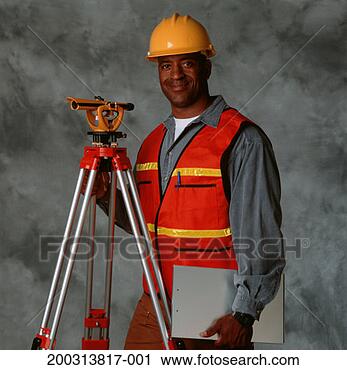 Stock Photography - building surveyor 
wearing helmet, 
 with theodolite, 
 posing in. fotosearch 
- search stock 
photos, pictures, 
images, and photo 
clipart