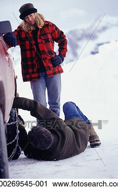 Stock Photography - man putting snow 
chains on tyres, 
woman watching. 
fotosearch - search 
stock photos, 
pictures, images, 
and photo clipart