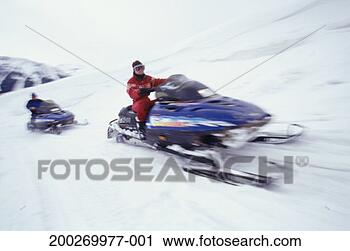 Stock Photography - two people riding 
snowmobiles. fotosearch 
- search stock 
photos, pictures, 
images, and photo 
clipart