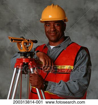 Stock Photography - building surveyor 
wearing helmet, 
 with theodolite, 
 posing in. fotosearch 
- search stock 
photos, pictures, 
images, and photo 
clipart