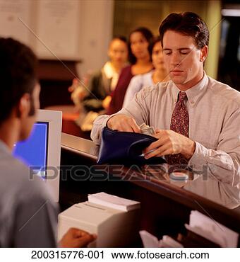 Stock Photography - man putting money 
into wallet at 
bank counter. 
fotosearch - search 
stock photos, 
pictures, images, 
and photo clipart