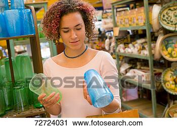 Stock Photography - young woman comparing 
glass cups in 
shop. fotosearch 
- search stock 
photos, pictures, 
images, and photo 
clipart