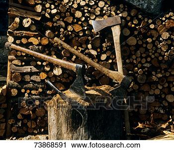 Stock Photography - axes in tree stump, 
in front of pile 
of chopped wood. 
fotosearch - search 
stock photos, 
pictures, images, 
and photo clipart