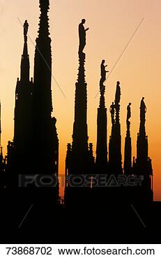 Stock Photo - italy,  milan, 
 silhouettes of 
statues on pinnacles 
of cathedral at. 
fotosearch - search 
stock photos, 
pictures, images, 
and photo clipart