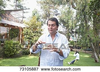 Picture - mature man eating 
a snack in a garden. 
fotosearch - search 
stock photos, 
pictures, images, 
and photo clipart