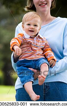 Stock Photography - mother holding 
son (9-12 months) 
outdoors, smiling. 
fotosearch - search 
stock photos, 
pictures, images, 
and photo clipart