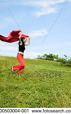 Stock Photography - woman running 
down hill holding 
cape over head. 
fotosearch - search 
stock photos, 
pictures, images, 
and photo clipart