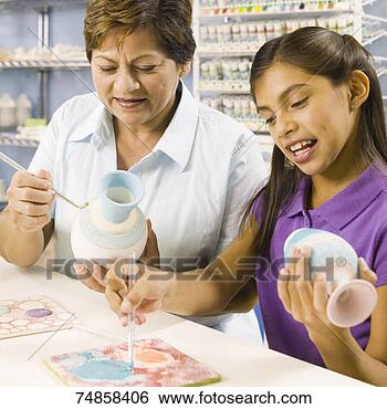 Stock Photo - grandmother and 
granddaughter 
(10-11) painting 
pottery in ceramics. 
fotosearch - search 
stock photos, 
pictures, images, 
and photo clipart