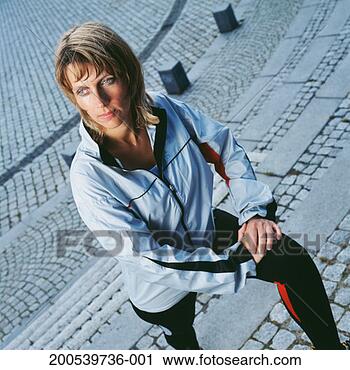 Stock Photography - mature woman wearing 
running clothes 
stretching leg 
on steps. fotosearch 
- search stock 
photos, pictures, 
images, and photo 
clipart