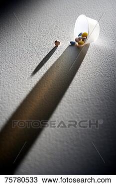 Stock Photo - pills in overturned 
plastic container, 
backlit and casting 
long shadow. fotosearch 
- search stock 
photos, pictures, 
images, and photo 
clipart