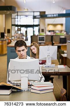 Banco de Imagem - adolescente,  
menino,  usando, 
 computador,  
biblioteca. fotosearch 
- busca de fotos, 
imagens e clipart
