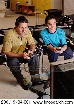 Stock Photography - father and son 
(13-15) watching 
television. fotosearch 
- search stock 
photos, pictures, 
images, and photo 
clipart