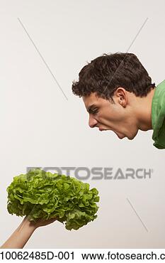 Stock Photography - young man screaming 
at lettuce being 
held by unrecognizable 
person. fotosearch 
- search stock 
photos, pictures, 
images, and photo 
clipart
