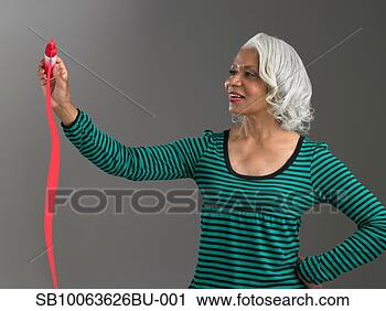 Stock Photography - mature woman squeezing 
tube of red paint. 
fotosearch - search 
stock photos, 
pictures, images, 
and photo clipart