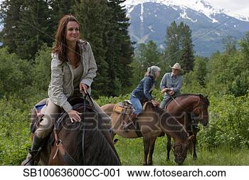 Stock Photography - mid adult woman 
and senior couple 
horseback riding, 
 mountain in. 
fotosearch - search 
stock photos, 
pictures, images, 
and photo clipart
