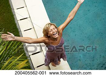 Stock Photography - woman standing 
in rain by outdoor 
pool, arms raised, 
overhead view. 
fotosearch - search 
stock photos, 
pictures, images, 
and photo clipart