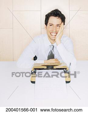 Stock Photography - young man sitting 
by typewriter, 
smiling. fotosearch 
- search stock 
photos, pictures, 
images, and photo 
clipart