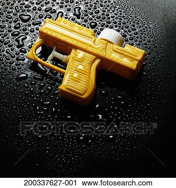 Stock Photography - yellow water pistol 
on black surface 
covered in water 
droplets. fotosearch 
- search stock 
photos, pictures, 
images, and photo 
clipart