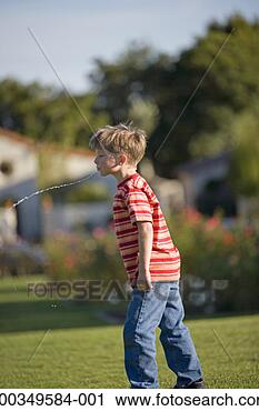 Stock Photography - boy (6-8) spitting 
water on lawn, 
profile. fotosearch 
- search stock 
photos, pictures, 
images, and photo 
clipart