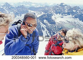 Stock Photography - four people on 
top of mountain, 
man speaking on 
mobile phone. 
fotosearch - search 
stock photos, 
pictures, images, 
and photo clipart