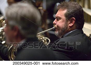 Stock Photography - french horn player 
in orchestra during 
performance, side 
view. fotosearch 
- search stock 
photos, pictures, 
images, and photo 
clipart