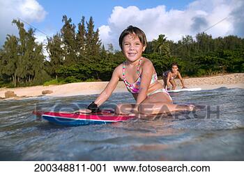 Stock Photography - girl sitting on 
body board in 
water, smiling, 
portrait. fotosearch 
- search stock 
photos, pictures, 
images, and photo 
clipart