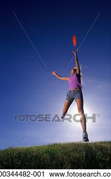 Stock Photography - young woman jumping 
to reach plastic 
disc, low angle 
view (sun flare). 
fotosearch - search 
stock photos, 
pictures, images, 
and photo clipart