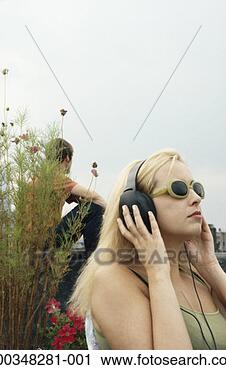 Stock Photography - young woman wearing 
headphones and 
sunglasses, sideview. 
fotosearch - search 
stock photos, 
pictures, images, 
and photo clipart