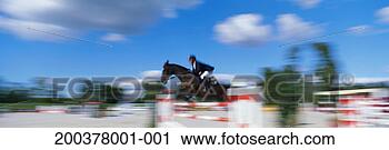 Stock Photography - horse and rider 
show jumping (blurred 
motion). fotosearch 
- search stock 
photos, pictures, 
images, and photo 
clipart