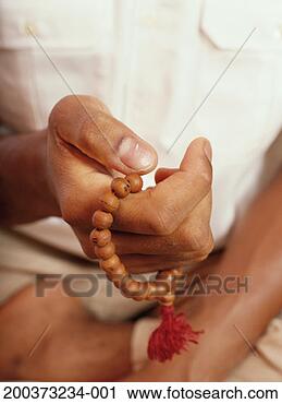 Stock Photography - man holding buddhist 
prayer beads, 
close-up of hand. 
fotosearch - search 
stock photos, 
pictures, images, 
and photo clipart