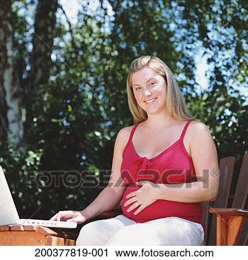 Stock Photography - pregnant woman 
sitting outside, 
working on laptop, 
smiling, portrait. 
fotosearch - search 
stock photos, 
pictures, images, 
and photo clipart