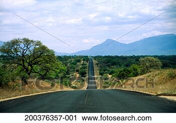 Stock Photography - rural road through 
bush land, drakensberg 
mountain range 
in distance. fotosearch 
- search stock 
photos, pictures, 
images, and photo 
clipart