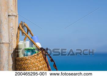 Stock Photography - beach bag hanging 
on bamboo post 
by coast, close-up. 
fotosearch - search 
stock photos, 
pictures, images, 
and photo clipart