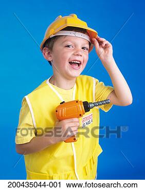Stock Photography - boy (4-6) in toy 
hard hat holding 
toy drill, smiling, 
portrait. fotosearch 
- search stock 
photos, pictures, 
images, and photo 
clipart