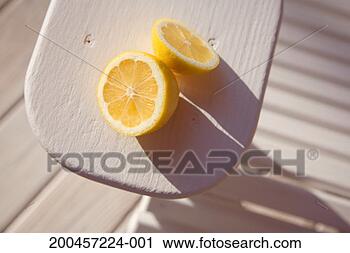 Stock Photography - lemon cut in half 
on arm of outdoor 
chair, elevated 
view, close-up. 
fotosearch - search 
stock photos, 
pictures, images, 
and photo clipart