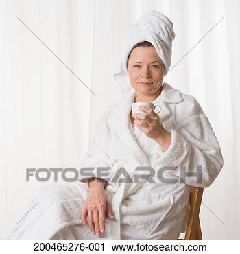 Stock Photography - mature woman wearing 
robe, sitting 
down holding tea 
cup, portrait. 
fotosearch - search 
stock photos, 
pictures, images, 
and photo clipart