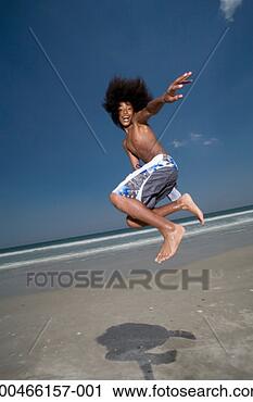 Stock Photography - teenager (13-15) 
jumping in air 
on beach, side 
view. fotosearch 
- search stock 
photos, pictures, 
images, and photo 
clipart