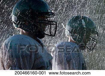Stock Photography - two american football 
players in rain, 
side view. fotosearch 
- search stock 
photos, pictures, 
images, and photo 
clipart